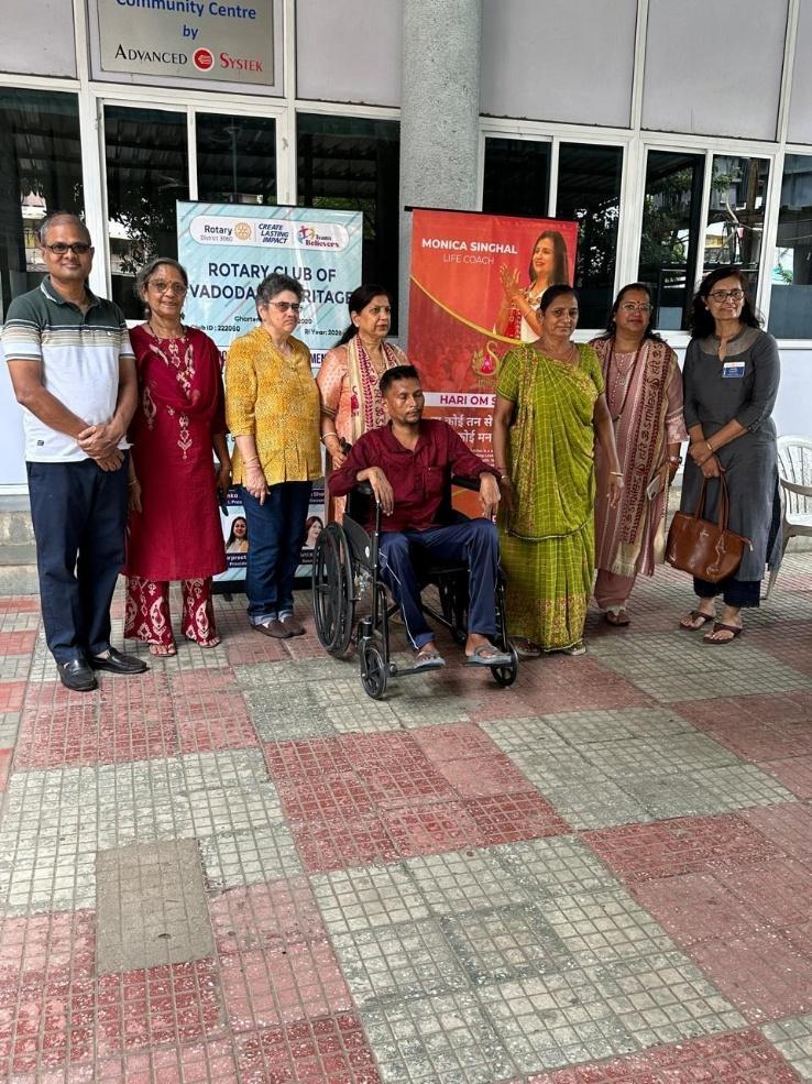 Handing over wheelchair to beneficiary at Rotary Hall